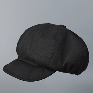 Détail de la texture en lin sur une casquette gavroche noire minimaliste chic