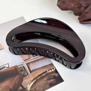 Detail view of large tortoiseshell acrylic crescent hair claw clip with smooth glossy finish