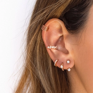 Close-up of rose gold earring set featuring hoop cuffs and diamond-encrusted studs