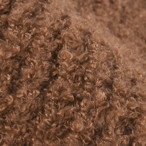 Detailopname van bruine teddy fleece stof op een warme winter gebreide muts voor dames