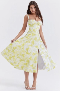 Detail showing elegant high side slit on the yellow floral midi dress with refined draping