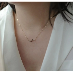 Detail of 14k gold plated sterling silver necklace with multiple heart pendants on model