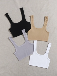 Débardeurs de sport en tricot côtelé en noir, abricot, lilas et blanc à plat sur le tissu