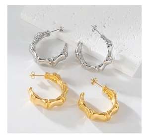 Macro detail of C-shaped bamboo texture earrings in polished gold and silver finishes