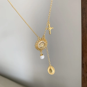 925 silver sunburst necklace with pearl and gold cross on a layered link chain