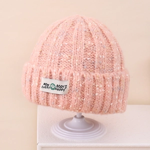 Detailed macro view of pink melange knit texture and embroidered happy face logo patch