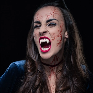 Detailed realistic vampire fangs and facial vein tattoos for Halloween makeup look