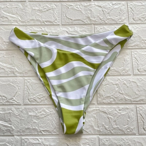 Detail view of high-waisted bikini bottoms with green and white abstract swirl patterns