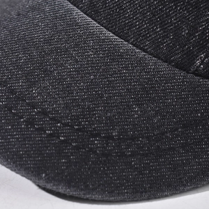 Close-up of black denim short brim with double stitching and faded vintage texture