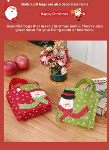 Close-up of felt Christmas gift bags with snowman embroidery and festive decor on wood