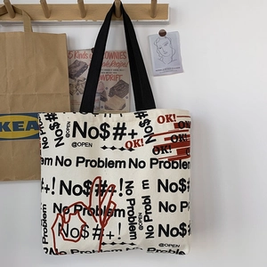 Dettaglio della borsa tote in tela con stampe graffiti e manici in fettuccia nera