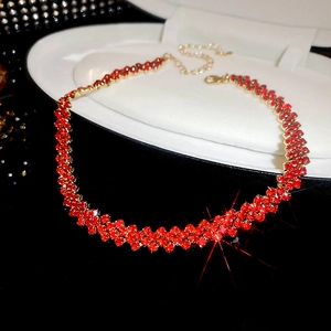 Detail of elegant gold choker with dense red rhinestones on a white display tray