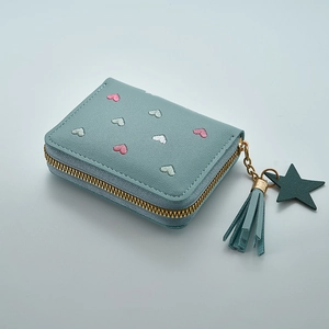 Detail of light blue leather wallet with heart embroidery and tassel zipper charm