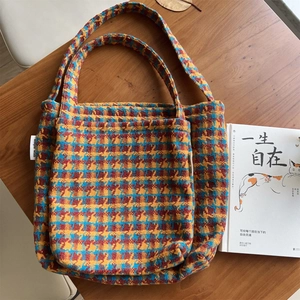 Retro houndstooth knit tote bag with three-color texture on a vintage wooden table