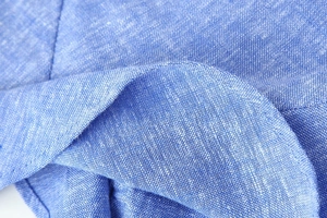 Close-up of light blue linen blend fabric texture and fine stitching detail