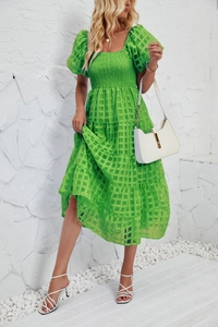 Detail of smocked elastic chest and square neckline on bright green plaid summer dress