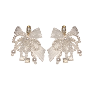 Elegant bow earrings with white lace, pearls, and crystal tassels on white background