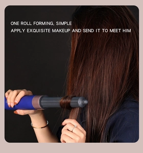 Macro view of blue and gold automatic curling iron styling long brown hair gently