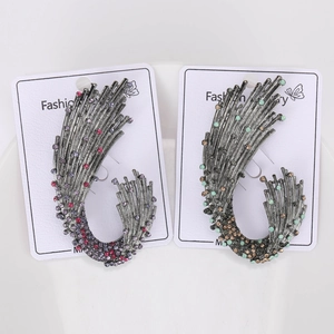 Detailed close-up of vintage feather brooches with colorful rhinestones on cards