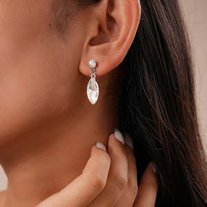 Close-up of sparkling silver marquise-cut crystal earrings worn by a female model