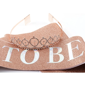 Detail of rose gold glitter sash with TO BE text and rhinestone party crown