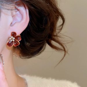 Detail of red flower earring with 18K gold plating and sparkling zircon centerpiece
