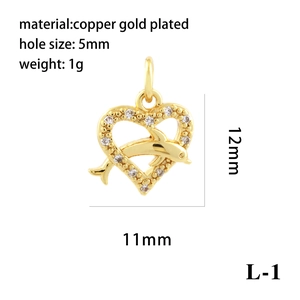 Macro view of 18K gold plated heart and dolphin pendant with white zircon stones