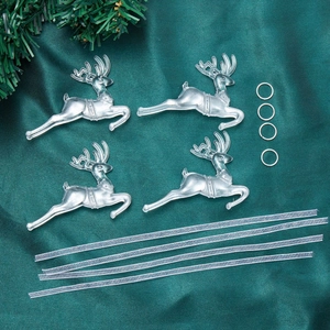 Close-up of four transparent acrylic reindeer ornaments with silver rings on green satin