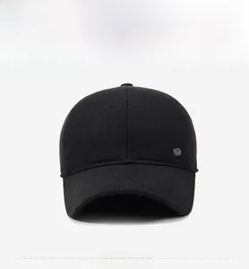 Front view of black knit baseball cap with a round metal badge and warm fabric texture