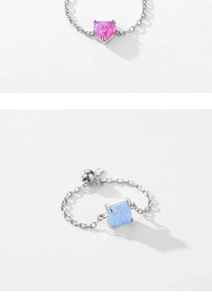 Close-up of adjustable 925 silver rings with heart pink and square blue opal stones