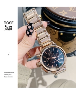 Detail of rose gold metal chain watch with black chronograph dial and date window