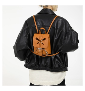 Petit sac à dos tendance pour femme en cuir marron avec un design papillon et boucle.