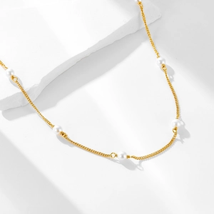 Elegant s925 sterling silver gold chain necklace with white pearls on marble base