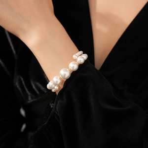 Détail d'un bracelet de perles multicouche avec séparateurs dorés sur velours noir