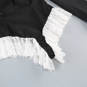 Detailed view of black fabric with white lace trim and cloth-covered buttons on bodysuit