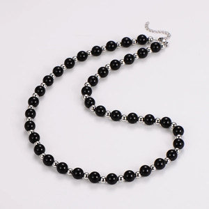 Macro view of black obsidian beads with silver spacers and adjustable extender chain