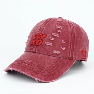 Detailed macro view of distressed burgundy baseball cap with 3D embroidery and vintage texture