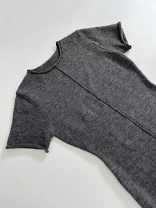 Detailed macro view of soft knit grey mini dress featuring exposed seams and rolled edges