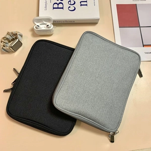 Flat lay of black and grey Apple Watch strap storage pouches on a desk with accessories