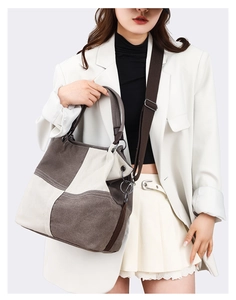 Detailed view of canvas tote bag featuring brown and cream patchwork and wide strap