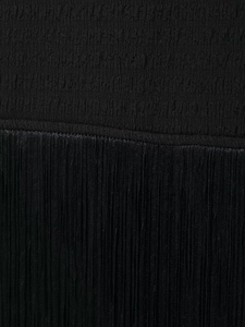 Détail du tissu extensible plissé noir avec décoration de franges délicates sur la robe
