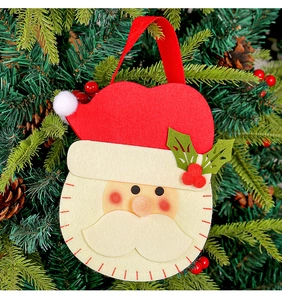 Christmas Santa felt gift bag hanging as a decoration on a lush Christmas tree branch