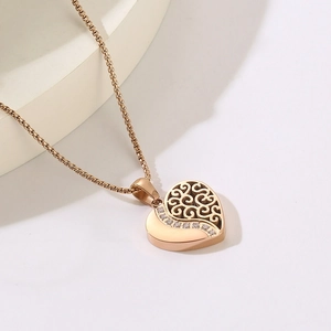 Détail du pendentif cœur en or rose avec motif ajouré et incrustation de zircons