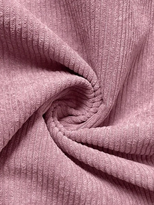 Close-up of pink corduroy fabric showing detailed vertical texture and soft ribbed material