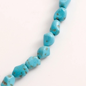 Macro detail of natural turquoise beads with unique textures and brown mineral patterns