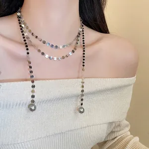 Three-layer silver metal chain necklace with grey pearl pendants on model