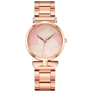 Detail of rose gold watch dial with tropical palm leaf pattern and metallic mesh strap