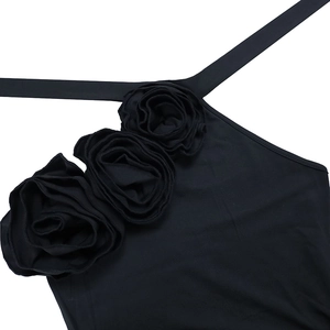 Detail of elegant black dress showing three 3D fabric roses on the halter neckline