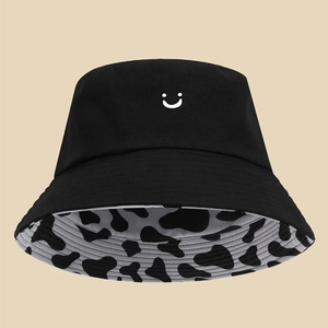 Dettaglio del cappello a secchiello in cotone con motivo smiley e tesa con stampa mucca