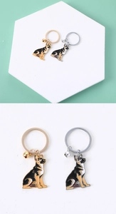 Close-up of metal German Shepherd keychains with bells in gold and silver finish